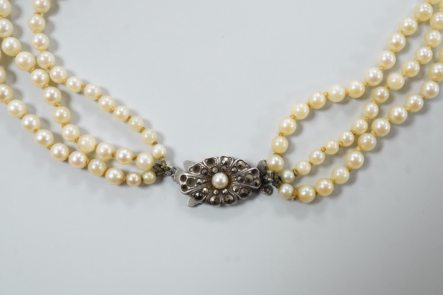 A triple strand graduated cultured pearl necklace, with marcasite set sterling clasp(a.f.), approximately 38cm.